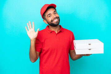 Pizza delivery Brazilian man with work uniform picking up pizza boxes isolated on blue background...