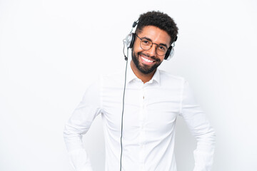 Telemarketer Brazilian man working with a headset isolated on white background posing with arms at hip and smiling