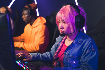 Professional e-sport gamer girl streaming and plays online video game on PC. High quality photo