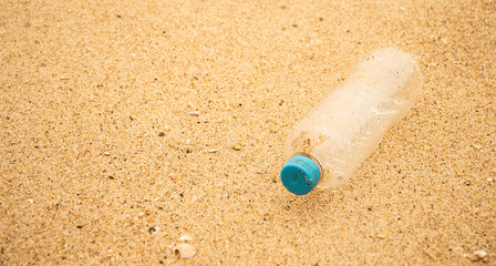 pet bottle thrown on the beach sand. Garbage and human pollution on the beaches nature