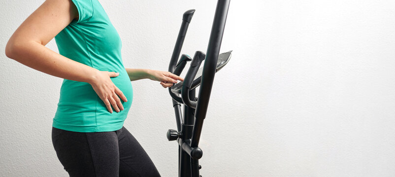 Unrecognizable pregnant woman exercising at home