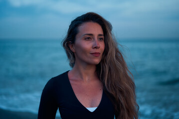 Naklejka premium yogui woman standing at the beach while blue hour on sunset