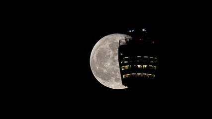 Full moon behind the Stuttgart TV Tower. Close-up of the tower restaurant and technical equipment against craters of the moon. Stuttgart, Germany April 18, 2022 © Martin Gruber