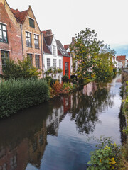 The historical city center of Bruges with medieval brick houses along a canal
