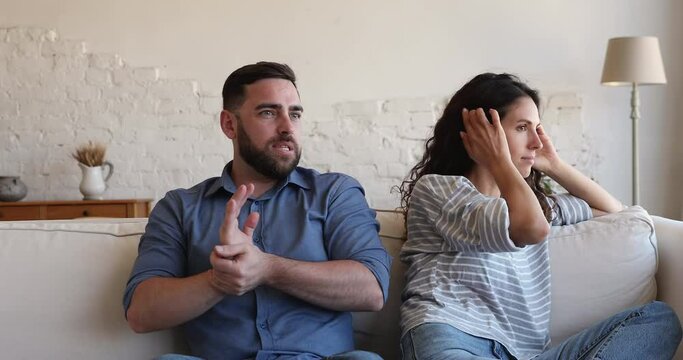 Marriage difficulties. Angry nervous married couple sit on couch quarrel has disagreement misunderstanding find fault with one another discuss problem with family psychologist at online webcam session
