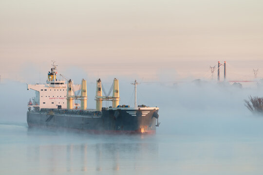 Large bulk cargo ship underway in fog. Foggy big bulker vessel cargo export and import operation.