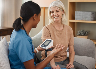 Time to get pumped up about your health. Shot of a doctor examining a senior woman with a blood pressure gauge at home.