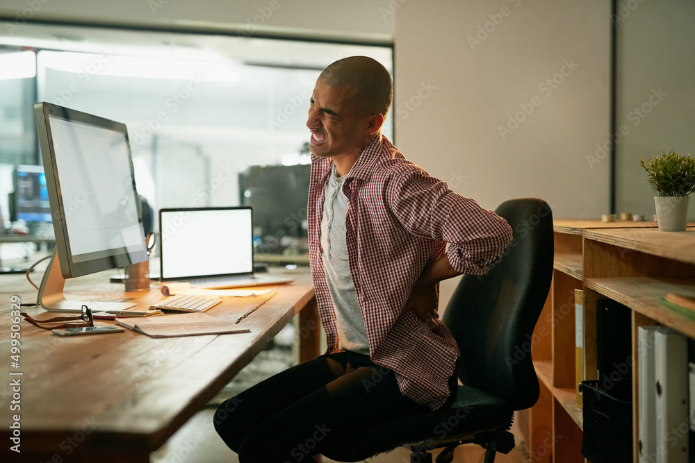 Poster suffering from the consequences of poor posture. cropped shot of a young designer experiencing back 