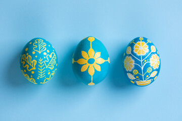 Macro view of Easter eggs painted with Ukrainian national colors, blue and yellow, and depicting...