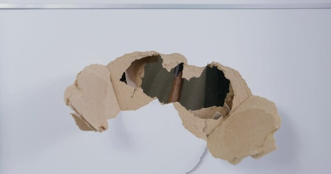 Man breaks white door with axe destroying and making big hole from inside in flat. Broken plasterboard door and damage in modern house close view
