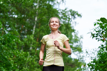 Young fitness woman running at forest trail.