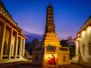 Buddhist monk in buddhism temple reading Buddhist lessen book at night