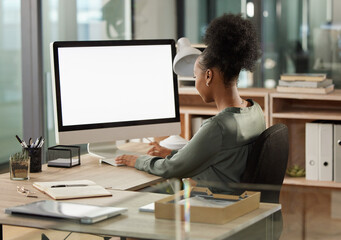 Shes focused on the task at hand. Rearview shot of an unrecognizable young businesswoman working at her desk in the office.
