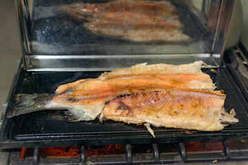 Hot grilled trout with salt and seasonings in a kitchen