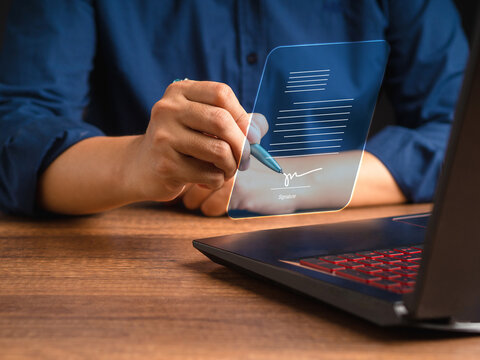 A businessman using a pen signing electronic documents on digital documents on a virtual screen