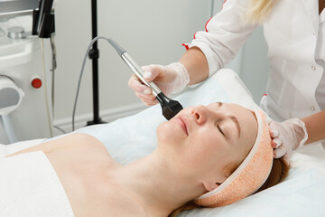 Obraz na płótnie Canvas A woman receives laser treatment of the face in a cosmetology clinic, a concept of skin rejuvenation is being developed. laser peeling