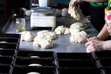 Laying the dough in the molds for future bread.