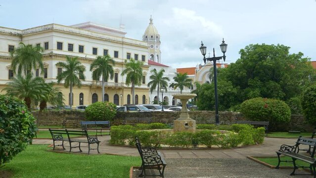 San Francisco de Asis Church overlooks a stunning park in downtown Panama City full of tropical greenery. Lush green palm trees surround an idyllic park in the historic Casco Viejo neighborhood.