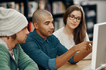 Studying with friends has its benefits. Cropped shot of three young university students studying in the library.