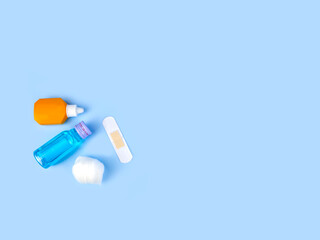 povidone iodine, Isopropyl Alcohol, cotton ball and Medical plaster on isolated blue background.Copy space blank area for text. Wound dressing equipment small set.