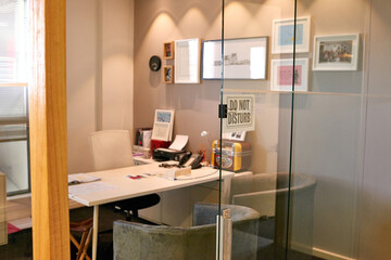 The boss office. Shot of an empty office with a Do Not Disturb sign in the window.