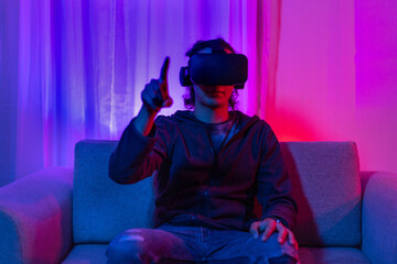 Man wearing virtual reality glasses is playing a 3D game with excitement, Bluetooth Remote Controller, VR, Future games, Gadgets, Technology, Red and blue background, VR game concept.