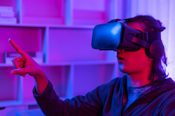 Man wearing virtual reality glasses is playing a 3D game with excitement, Bluetooth Remote Controller, VR, Future games, Gadgets, Technology, Red and blue background, VR game concept.