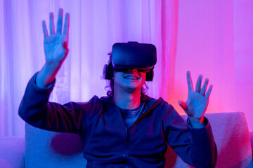 Man wearing virtual reality glasses is playing a 3D game with excitement, Bluetooth Remote Controller, VR, Future games, Gadgets, Technology, Red and blue background, VR game concept.