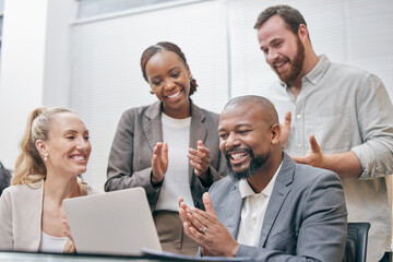 Fototapeta premium Theyre impressed. Cropped shot of a group of white collar businesspeople clapping while gathered around a laptop in the boardroom.