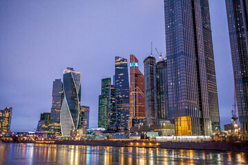 Fototapeta na wymiar April 1, 2022, Moscow Russia. Moscow City International Business Centre skyscraper buildings with panoramic windows night view. Moscow City at night. Lights are reflected in the river.