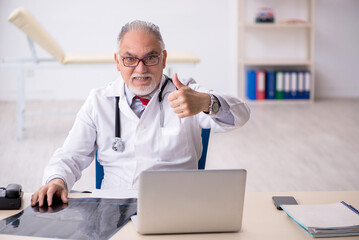 Old male doctor radiologist working in the clinic