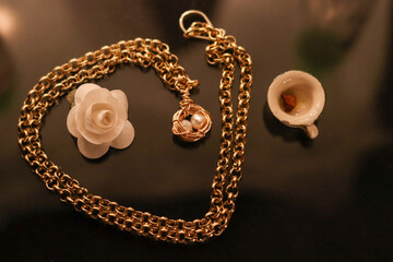 Naklejka premium Joyeria con cadena de oro con perla y decoracion blanca