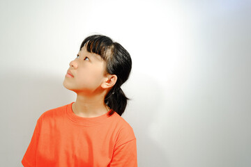 Portrait of young Asian girl with feelings and faces looking upwards isolated on white background.