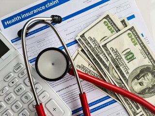 Health and medical insurance claim form with stethoscope on clipboard money dollars