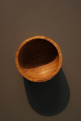 Isolated wooden bowl on brown background