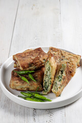 Martabak telur mini, Indonesian street food, fried wrap filled with eggs, minced meat, and vegetables.