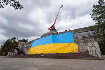 Ukrainische Flagge, hängt am ehemaligen Stalin-Denkmal, darüber Prager Metronom, Prag, Tschechien