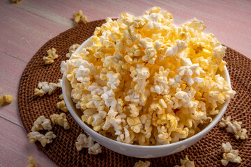 Popcorn in bown on wooden background. Popcorn in bowl on wooden table.