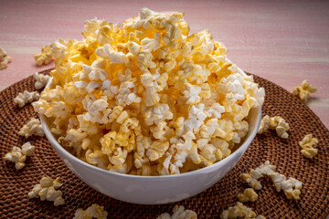 Popcorn in bown on wooden background. Popcorn in bowl on wooden table.