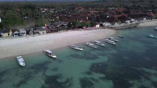 Calmer aerial view flight panorama overview drone footage of a dream beach with crystal clear turquoise water, boats floating at paradis island lembongan.
Cinematic view from above by Philipp Marnitz