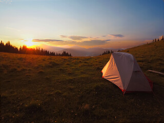  view of tourist tent in mountains at sunrise or sunset 