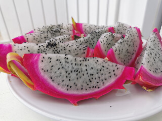 Pink outside and white inside with black seeds pitahaya (pitahaya or dragon's eye) - the fruit of Hylocereus cacti, cut into slices