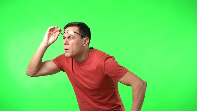 Blind male lifting glasses trying to see objects in distance