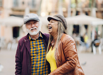 multiracial senior couple having fun in the city, retired travellers' life - focus on women -