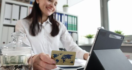 Smiling woman holding bank card and shopping online