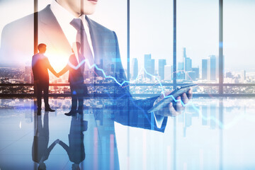 Creative image of businesspeople working together and using mobile device with falling downword forex chart on blurry office interior background with city view. 