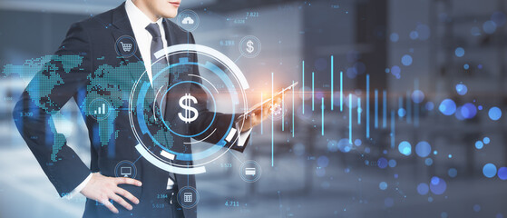 Businessman hand using tablet with creative glowing round dollar chart hologram on blurry wide office interior workplace background with bokeh circles and mock up place. 