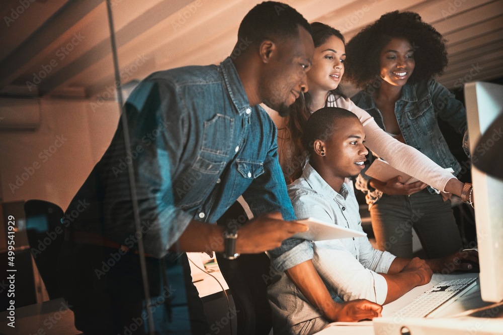 Poster getting the whole team involved. cropped shot of a group of young designers working together on a co
