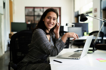 Happy businesswoman working on laptop. Portrait of beautiful businesswoman in the office..