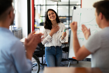 Obraz premium Businesswoman present her idea to working team. Young beautiful woman presenting businessplan..